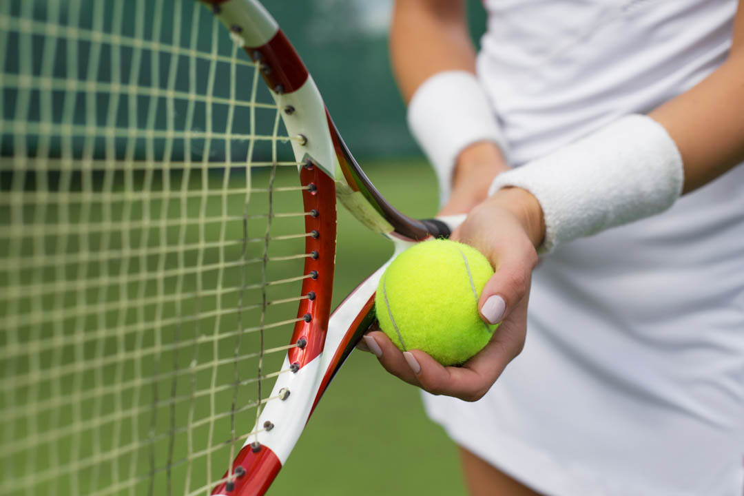 Tennis player holding racket and ball in hands